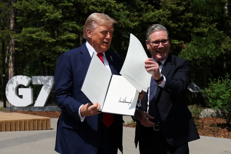 FILE PHOTO: U.S. President Donald Trump and British Prime Minister Keir Starmer hold a signed Trade Agreement during a meeting, at the G7 summit, in Kananaskis, Alberta, Canada, June 16, 2025. REUTERS/Suzanne Plunkett/Pool/File Photo