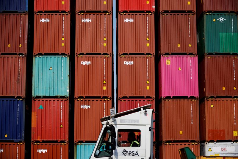 FILE PHOTO: FILE PHOTO: A truck driver works in front of shipping containers stacked up at Pusan Newport Terminal in Busan, South Korea, July 1, 2021. Picture taken on July 1, 2021. REUTERS/Kim Hong-Ji/File Photo/File Photo