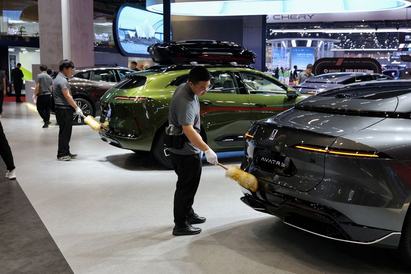 FILE PHOTO: Workers clean cars at the Avatr booth during a media day for the Auto Shanghai show in Shanghai, China April 24, 2025. REUTERS/Go Nakamura/File Photo
