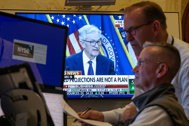 Traders work, as a screen broadcasts a news conference by U.S. Federal Reserve Chair Jerome Powell following the Fed rate announcement, on the floor of the New York Stock Exchange (NYSE) in New York City, U.S., June 18, 2025.  REUTERS/Brendan McDermid
