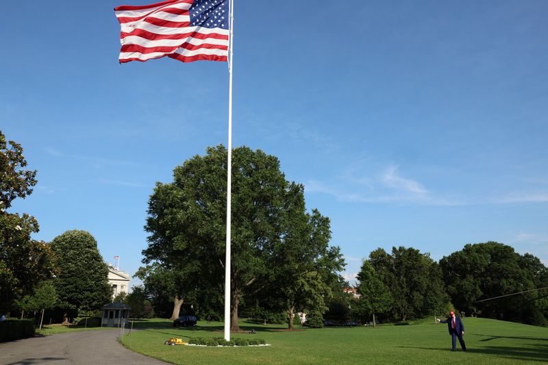 U.S. President Donald Trump gestures next to a new flagpole with the U.S. flag after disembarking Marine One upon arrival at the White House in Washington, D.C., U.S., June 21, 2025. REUTERS/Kevin Mohatt
