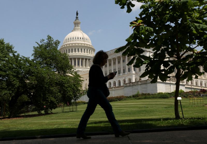 FILE PHOTO: A person walks the grounds of U.S. Capitol in Washington, D.C., U.S., May 16, 2025. REUTERS/Kevin Lamarque/File Photo