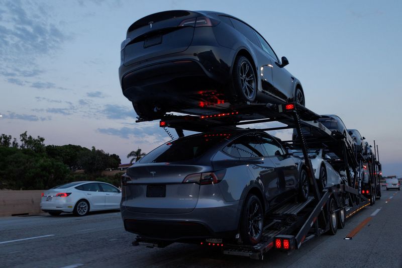 FILE PHOTO: Newly manufactured Tesla Model Y SUV vehicles are transported along a freeway near Carlsbad, California, U.S., September 9, 2024. REUTERS/Mike Blake/ File Photo