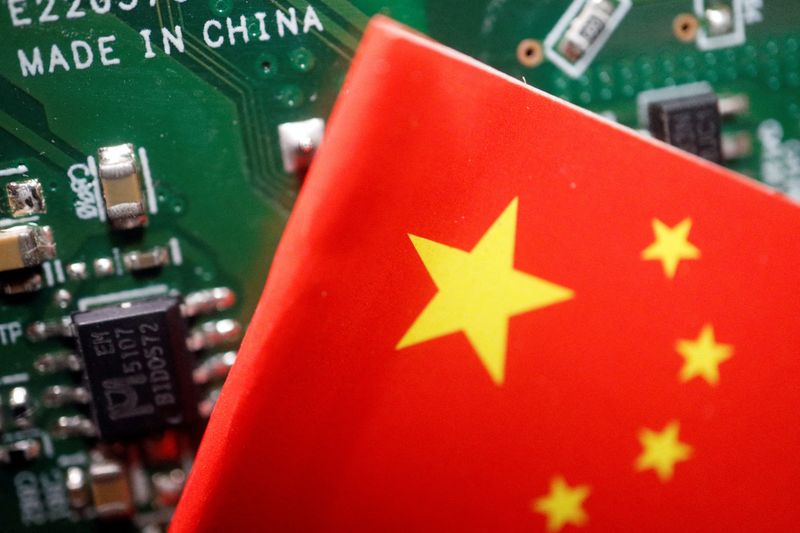 FILE PHOTO: A Chinese flag is displayed next to a "Made in China" sign seen on a printed circuit board with semiconductor chips, in this illustration picture taken February 17, 2023. REUTERS/Florence Lo/Illustration/File Photo