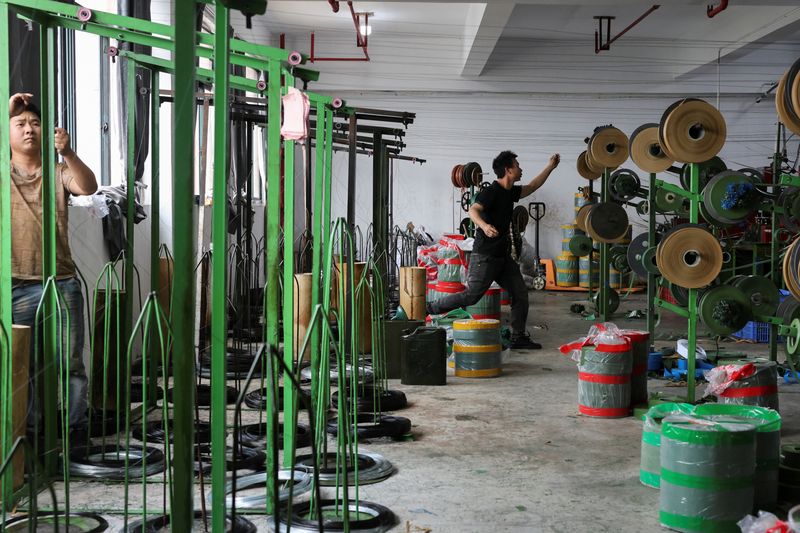 Employees work to produce artificial Christmas trees at a factory in Shaoxing, Zhejiang province, China, April 9, 2025.  REUTERS/Go Nakamura