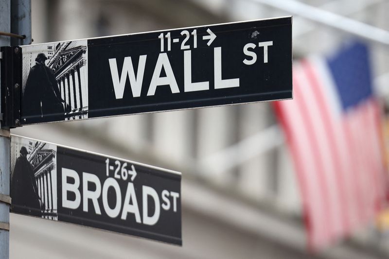 FILE PHOTO: A Wall Street sign hangs in front of a U.S. Flag outside the New York Stock Exchange (NYSE) in New York City, U.S., September 18, 2024. REUTERS/Andrew Kelly/File Photo