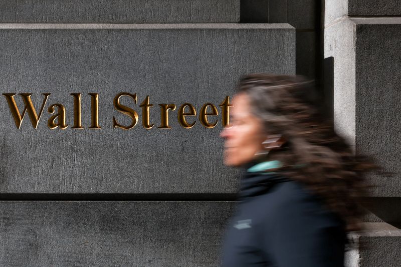 FILE PHOTO: A woman walks down Wall Street in New York City, U.S., April 8, 2025. REUTERS/Kylie Cooper/File Photo