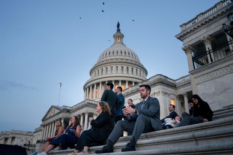 Senate staffers rest on the U.S. Capitol steps at sunrise as Republican lawmakers struggle to pass U.S. President Donald Trump's sweeping spending and tax bill, on Capitol Hill in Washington, D.C., U.S., July 1, 2025. REUTERS/Nathan Howard