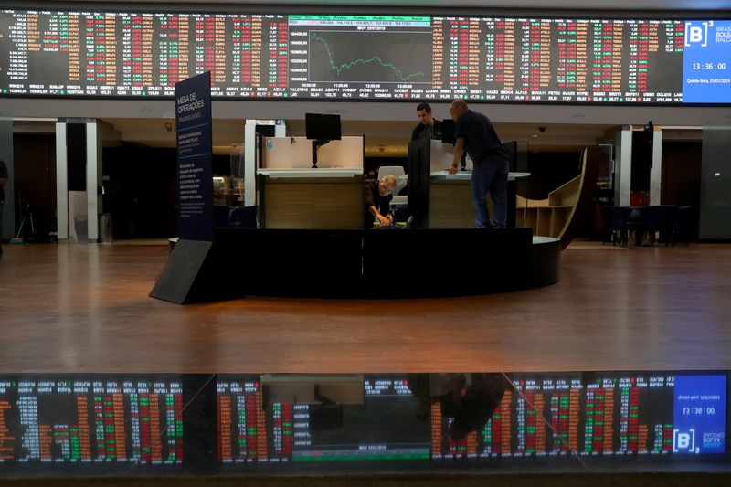 FILE PHOTO: An electronic board showing the graph of the recent fluctuations of market indices is seen as men work on the floor of Brazil's B3 Stock Exchange in Sao Paulo, Brazil, July 25, 2019. REUTERS/Amanda Perobelli/File Photo