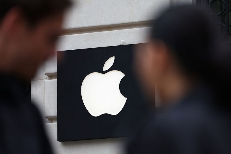 FILE PHOTO: People walk past an Apple logo at an Apple store in Paris, France, April 23, 2025. REUTERS/Abdul Saboor/ File Photo
