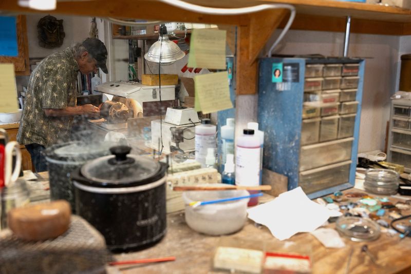 FILE PHOTO: Craftsperson George Graybeal polishes a hat pin at his rock shop in Marfa, Texas, U.S. June 23, 2025. REUTERS/Kaylee Greenlee/File Photo
