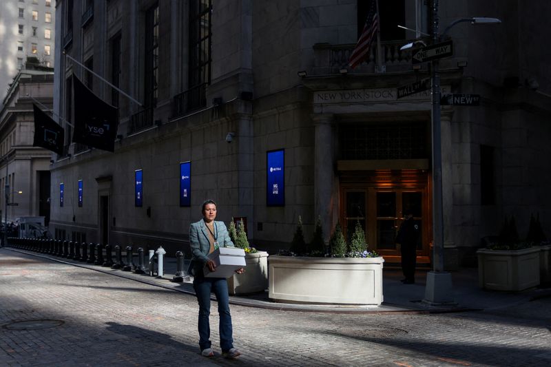 FILE PHOTO: A woman walks along Wall Street outside the New York Stock Exchange (NYSE) in New York City, U.S., April 9, 2025. REUTERS/Kylie Cooper/File Photo