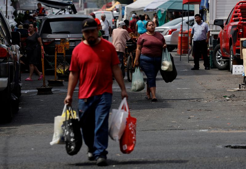 FILE PHOTO: People carry shopping bags as they walk near a market in Monterrey, Mexico May 16, 2024. REUTERS/Daniel Becerril/ File Photo
