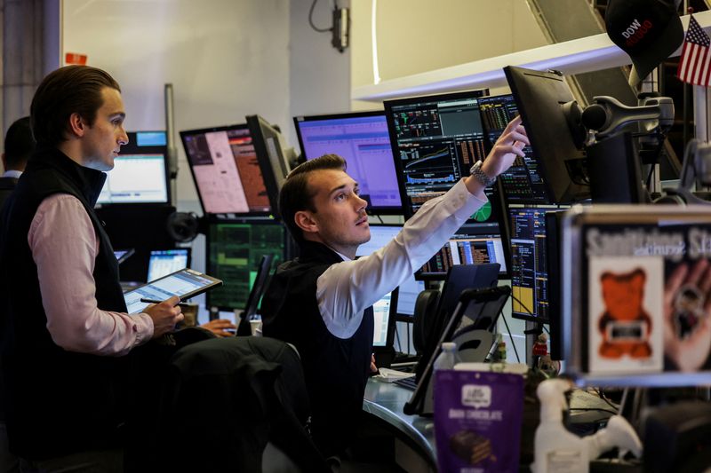 FILE PHOTO: Traders work on the floor at the New York Stock Exchange (NYSE) in New York City, U.S., July 8, 2025. REUTERS/Jeenah Moon/File Photo