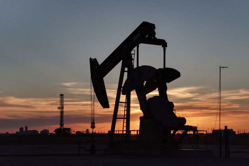FILE PHOTO: A drone view of a pump jack and drilling rig south of Midland, Texas, U.S. June 11, 2025. REUTERS/Eli Hartman/ File Photo