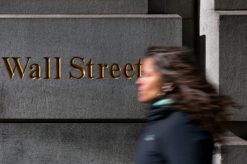FILE PHOTO: A woman walks down Wall Street in New York City, U.S., April 8, 2025. REUTERS/Kylie Cooper/File Photo
