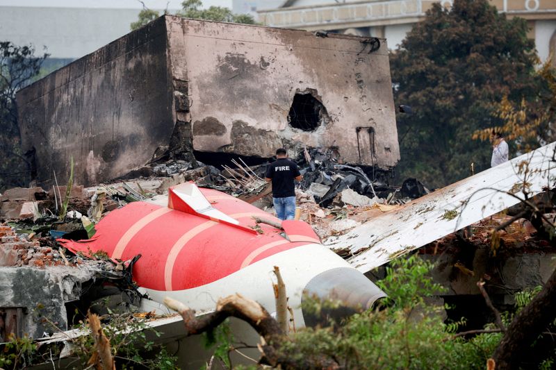 FILE PHOTO: A firefighter stands next to the crashed Air India Boeing 787-8 Dreamliner aircraft, in Ahmedabad, India, June 13, 2025. REUTERS/Adnan Abidi/File Photo