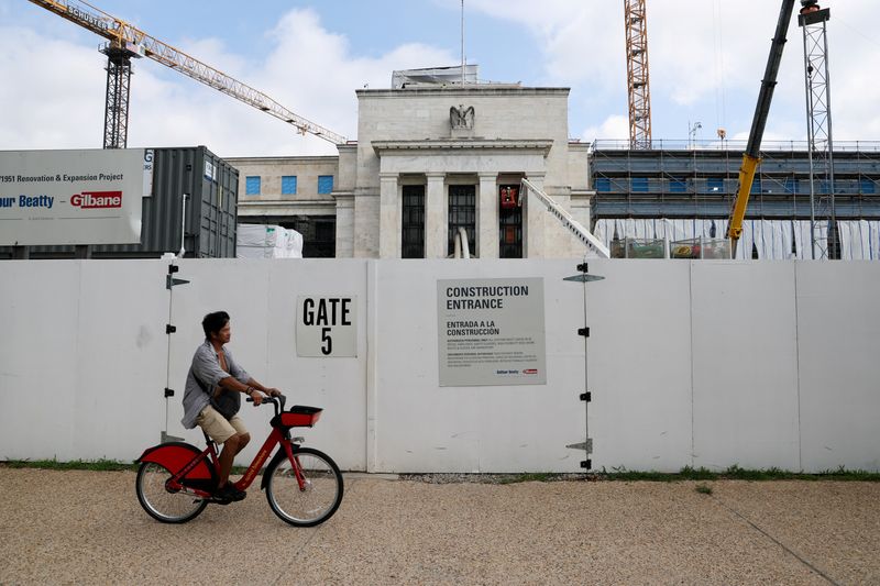 A person rides past the site of construction work at the U.S. Federal Reserve building as U.S. President Donald Trump voices complaints about Fed Chair Jerome Powell, in Washington, D.C., U.S., July 14, 2025. REUTERS/Jonathan Ernst
