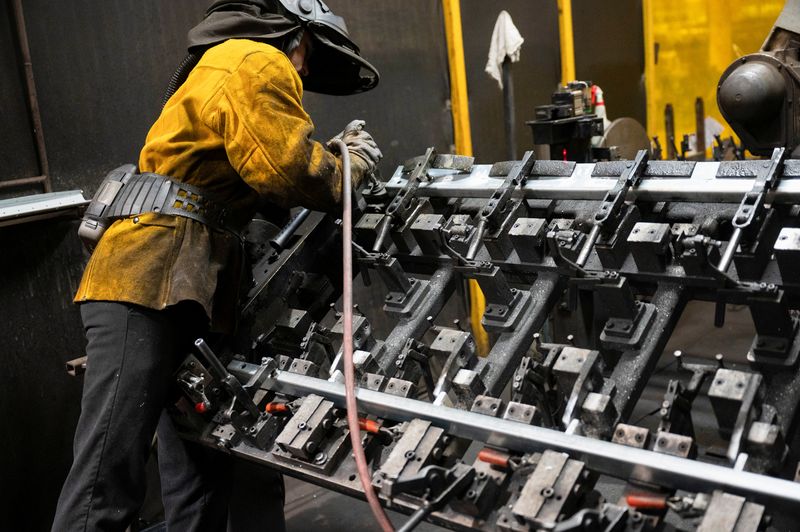 FILE PHOTO: A worker prepares steel to be automatically welded at HCC, a company that uses parts to make combines, at the factory in Mendota, Illinois, U.S., February 21, 2025. REUTERS/Vincent Alban/File Photo