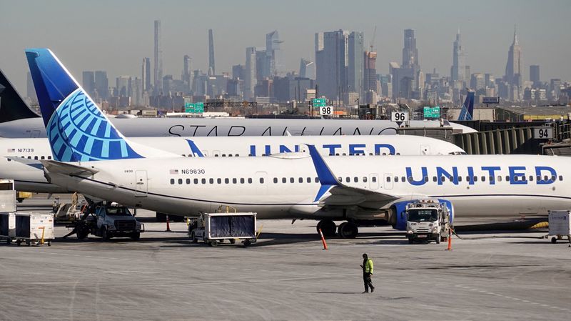 FILE PHOTO: A ground personel walks in front of United Airlines planes prepare to take off at Newark Liberty International Airport in Newark, New Jersey, , U.S., January 27, 2025. REUTERS/Fabrizio Bensch/File Photo