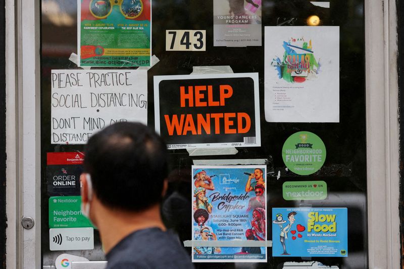 FILE PHOTO: A pedestrian passes a "Help Wanted" sign in the door of a hardware store in Cambridge, Massachusetts, U.S., July 8, 2022. REUTERS/Brian Snyder/File Photo