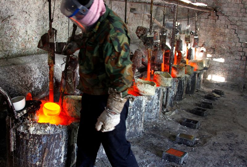FILE PHOTO: Ren Limin, a worker at the Jinyuan Company's smelting workshop, prepares to pour the rare earth metal Lanthanum into a mould near the town of Damao in China's Inner Mongolia Autonomous Region October 31, 2010. REUTERS/David Gray/File Photo