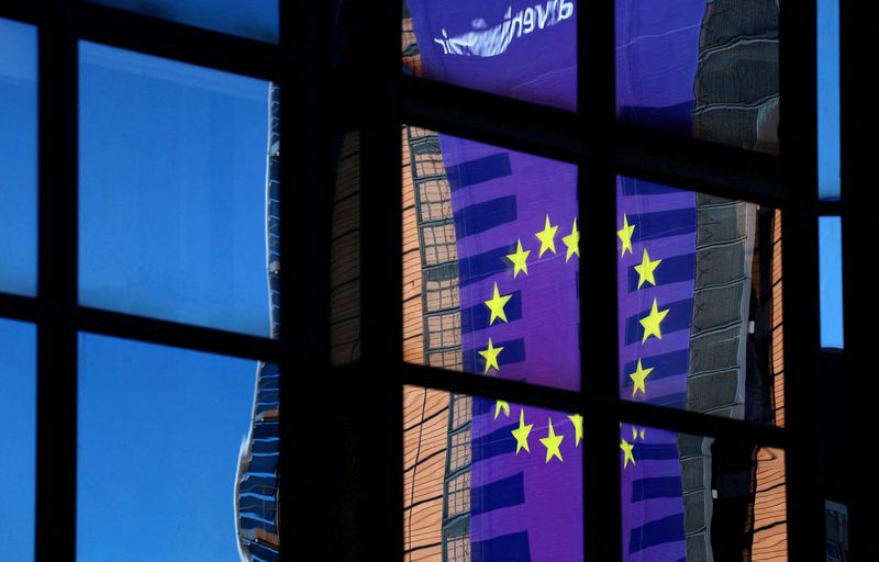 FILE PHOTO: A banner depicting an European Union flag is reflected in a window outside the EU Council headquarters in Brussels, Belgium March 18, 2025. REUTERS/Yves Herman//File Photo