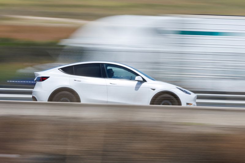 FILE PHOTO: A Tesla Model Y electric vehicle travels along a highway near San Juan Capistrano, California, U.S. July 1,  2025. REUTERS/Mike Blake/File Photo