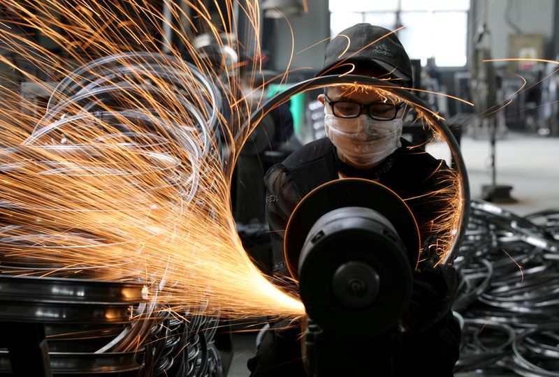 A worker polishes a bicycle steel rim at a factory manufacturing sports equipment in Hangzhou, Zhejiang province, China September 2, 2019. China Daily via REUTERS/File Photo