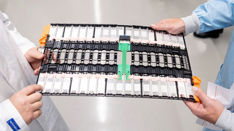 FILE PHOTO: Employees hold a plate with components at TE Connectivity in Woerth, Germany, February 16, 2022. Picture taken February 16, 2022. REUTERS/Lukas Barth/File Photo