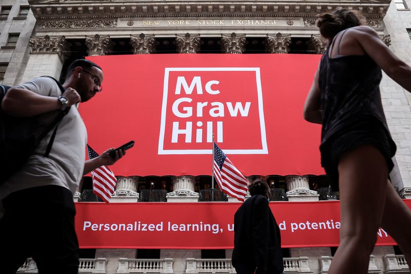 People pass by as a banner for publisher McGraw Hill is displayed during the company's IPO at the New York Stock Exchange (NYSE) in New York City, U.S., July 24, 2025.  REUTERS/Brendan McDermid