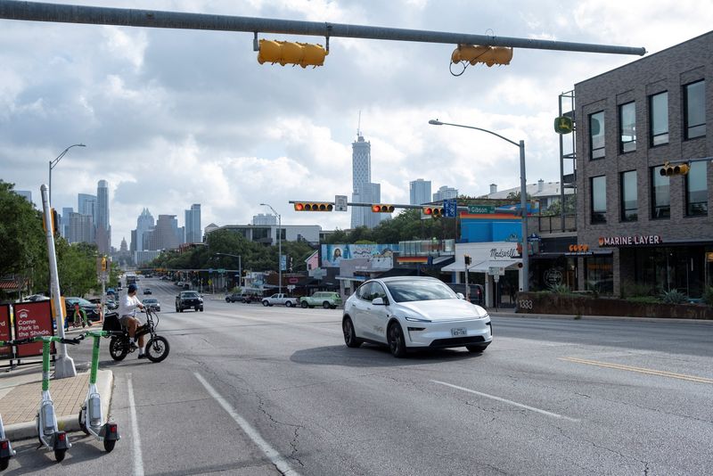 FILE PHOTO: A Tesla robotaxi drives on the street along South Congress Avenue in Austin, Texas, U.S., June 22, 2025. REUTERS/Joel Angel Juarez/File Photo