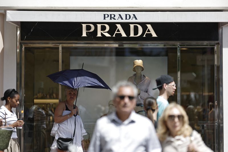 FILE PHOTO: People walk past a Prada shop during the 78th Cannes Film Festival in Cannes, France, May 21, 2025. REUTERS/Benoit Tessier/File Photo