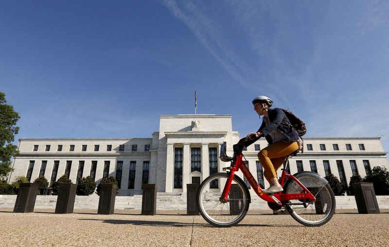 FILE PHOTO: A cyclist passes the Federal Reserve headquarters in Washington September 16, 2015. REUTERS/Kevin Lamarque/File Photo