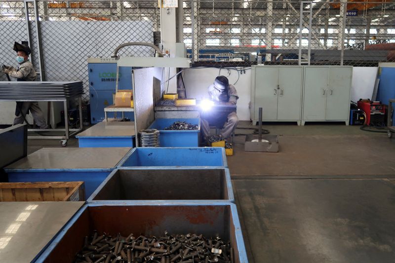 Employees work on the production line at Jingjin filter press factory in Dezhou, Shandong province, China August 25, 2022. REUTERS/Siyi Liu/File Photo