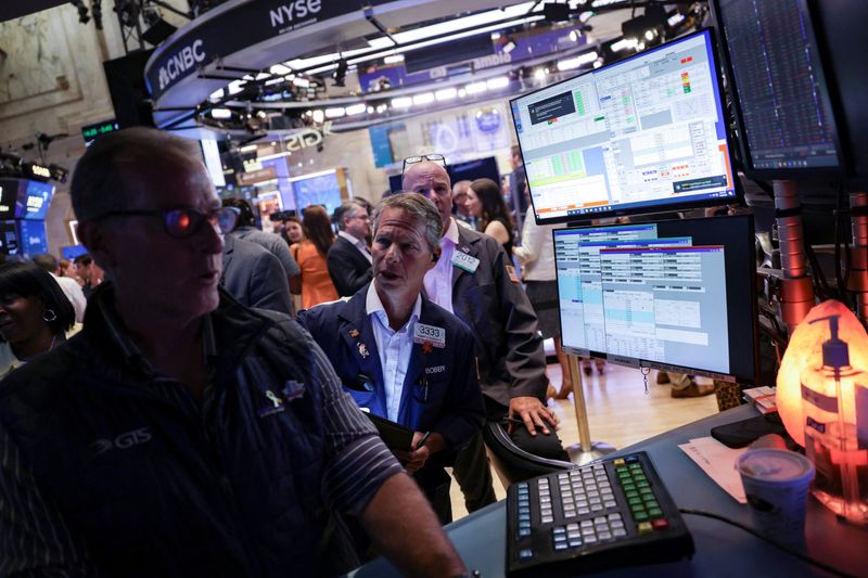 FILE PHOTO: Traders work on the floor at the New York Stock Exchange (NYSE) in New York City, U.S., July 30, 2025. REUTERS/Jeenah Moon/File Photo