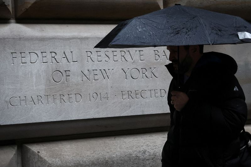 FILE PHOTO: A man passes by The Federal Reserve Bank of New York in New York City, U.S., March 13, 2023.  REUTERS/Brendan McDermid/File photo