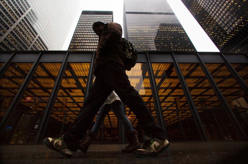FILE PHOTO: A man walks in front of buildings in the financial district in Toronto, January 28, 2013. REUTERS/Mark Blinch/File Photo