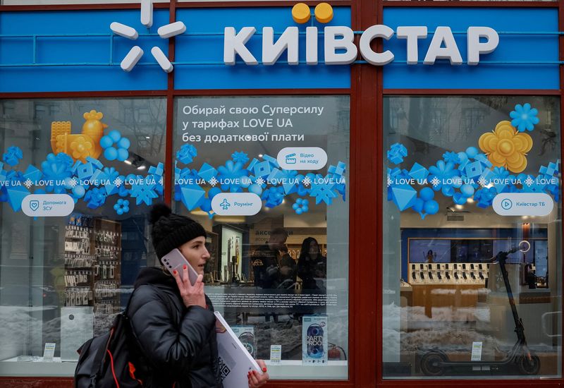 FILE PHOTO: A woman walks past a store of Ukrainian telecoms company Kyivstar, Ukraine, December 12, 2023. REUTERS/Alina Smutko/File Photo