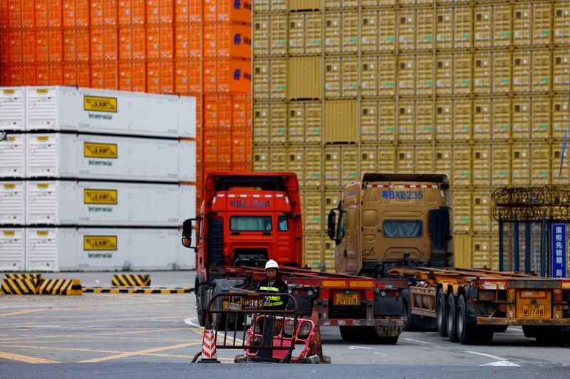 FILE PHOTO: A security personnel stands guard at an entrance to a container logistics centre at the Yantian port in Shenzhen, Guangdong province, China May 9, 2025. REUTERS/Tingshu Wang/File Photo