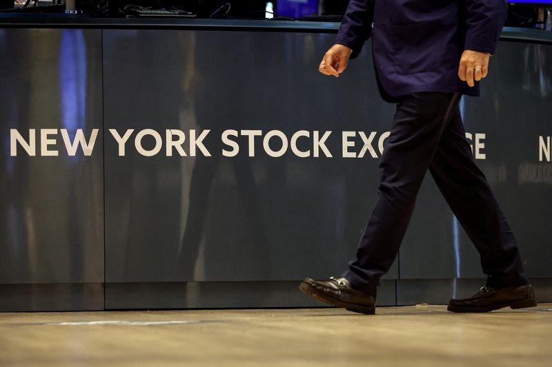 A trader walks past on the floor at the New York Stock Exchange (NYSE) in New York City, U.S., August 14, 2025.  REUTERS/Brendan McDermid/File Photo