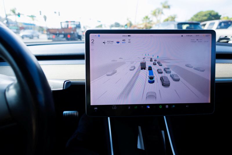 FILE PHOTO: A Tesla Model 3 vehicle drives using FSD (Full Self-Driving) in Encinitas, California, U.S., October 18, 2023. REUTERS/Mike Blake/File Photo