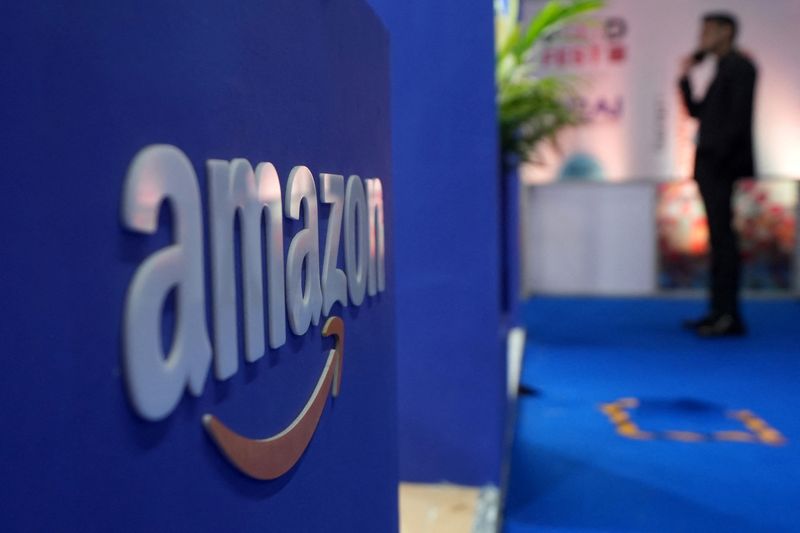 FILE PHOTO: A visitior stands near a logo of Amazon during the annual Retail Leadership Summit in Mumbai, India, February 27, 2025. REUTERS/Hemanshi Kamani/File Photo