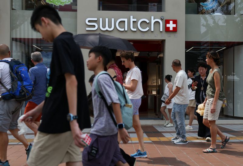 People walk past a store of Swiss watchmaker Swatch, in Beijing, China August 18, 2025. REUTERS/Tingshu Wang/File Photo