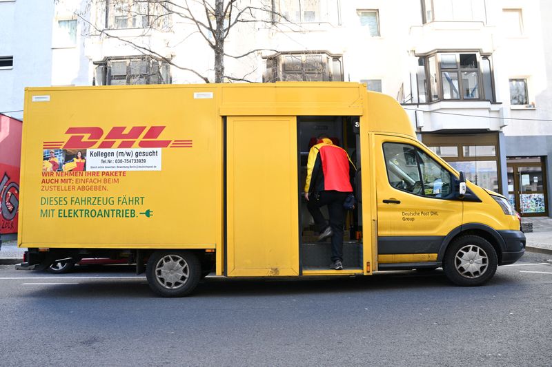 FILE PHOTO: A worker enters a vehicle of Deutsche Post DHL Group in Berlin, Germany March 6, 2025.  REUTERS/Annegret Hilse/File Photo