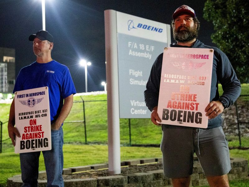 FILE PHOTO: Workers display picket signs, as they protest during a walkout by members of the International Association of Machinists and Aerospace Workers (IAM) over contract negotiations, outside Boeing company's facility, in Berkeley, Missouri, U.S., August 4, 2025 REUTERS/Lawrence Bryant/File Photo