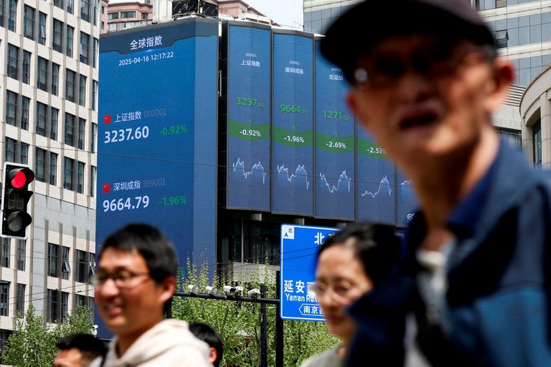 FILE PHOTO:  An electronic board shows Shanghai and Shenzhen stock indices in Shanghai, China April 16, 2025. REUTERS/Go Nakamura/ File Photo