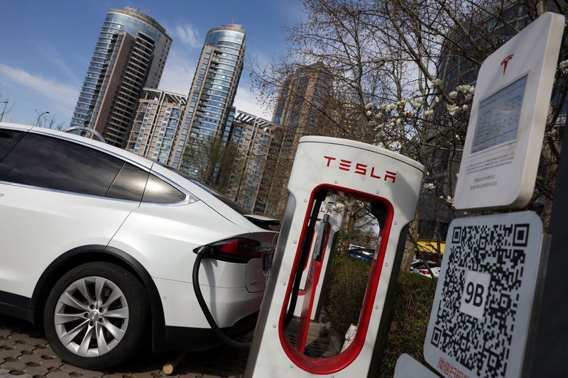 FILE PHOTO: A Tesla car charges at a Supercharger charging station of the electric vehicle (EV) maker in Beijing, China March 24, 2025. REUTERS/Florence Lo/File Photo