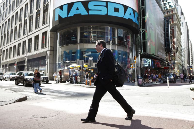 FILE PHOTO: A pedestrian walks past the NASDAQ building in New York City, April 30, 2010. Nasdaq OMX Group Inc reported a quarterly profit drop on Friday, missing expectations, as sluggish stock trading and one-time charges hurt the exchange operator.   REUTERS/Lucas Jackson (UNITED STATES)/File Photo