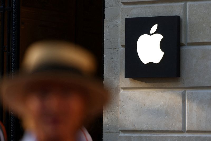 FILE PHOTO: A woman walks past an Apple logo at an Apple store in Paris, France, August 17, 2025. REUTERS/Abdul Saboor/File Photo